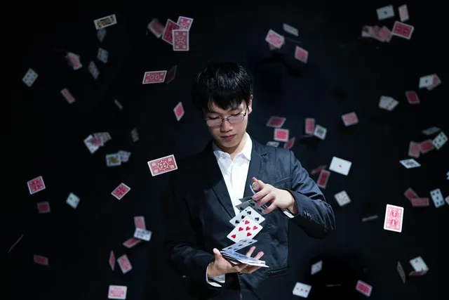 Mago haciendo un truco de cartas con la baraja volando a su alrededor
