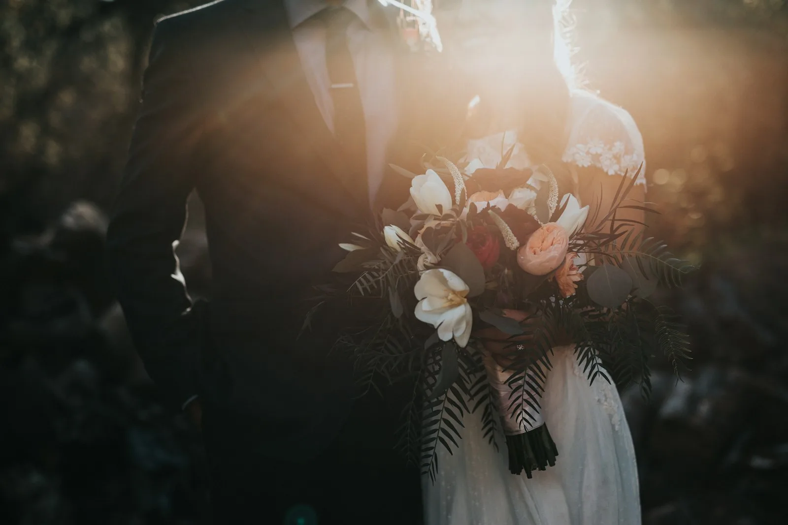 Novios con el ramo de flores a contraluz